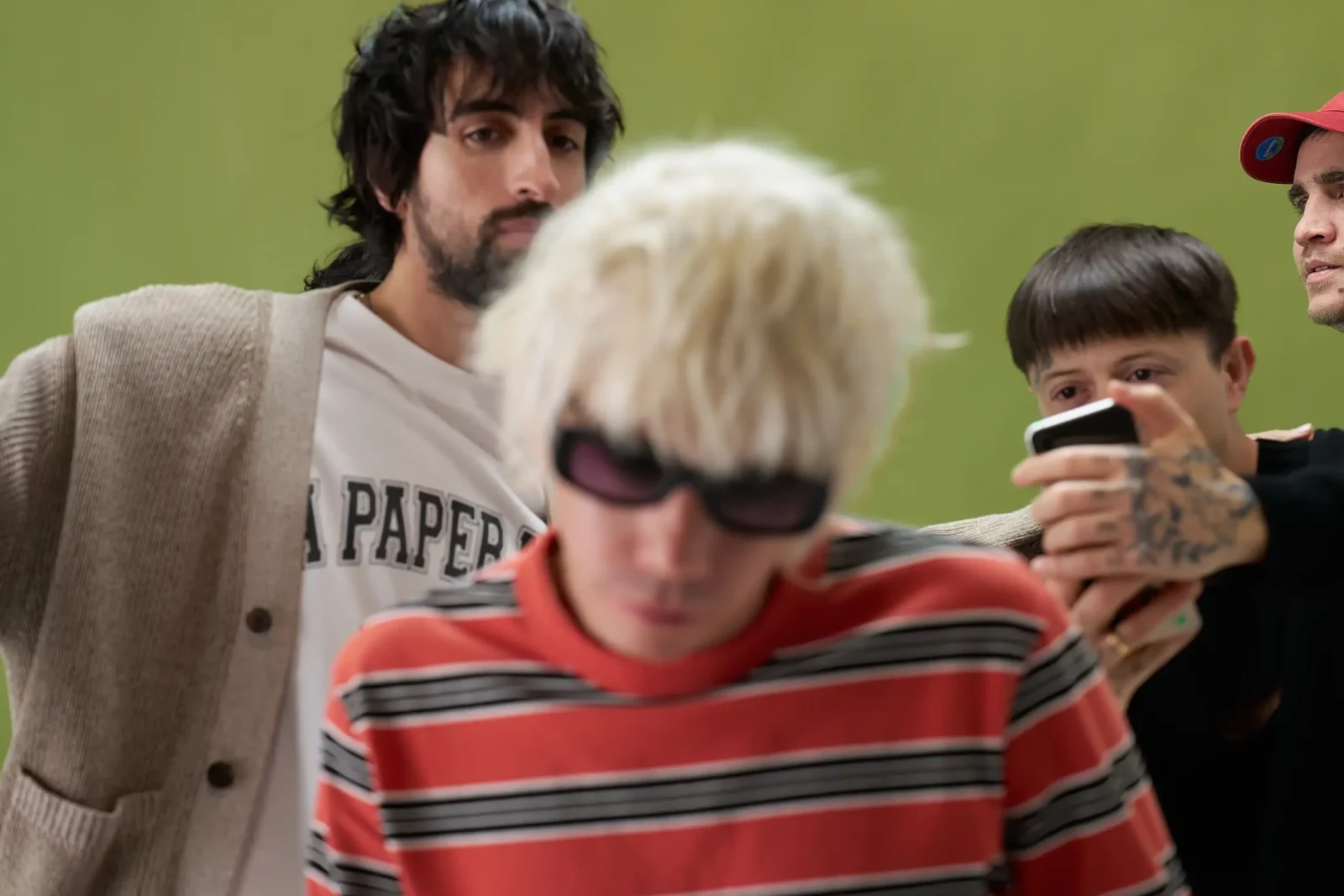 Candid group portrait of Cupido musicians in layered casual clothes, one wearing a striped sweater.
