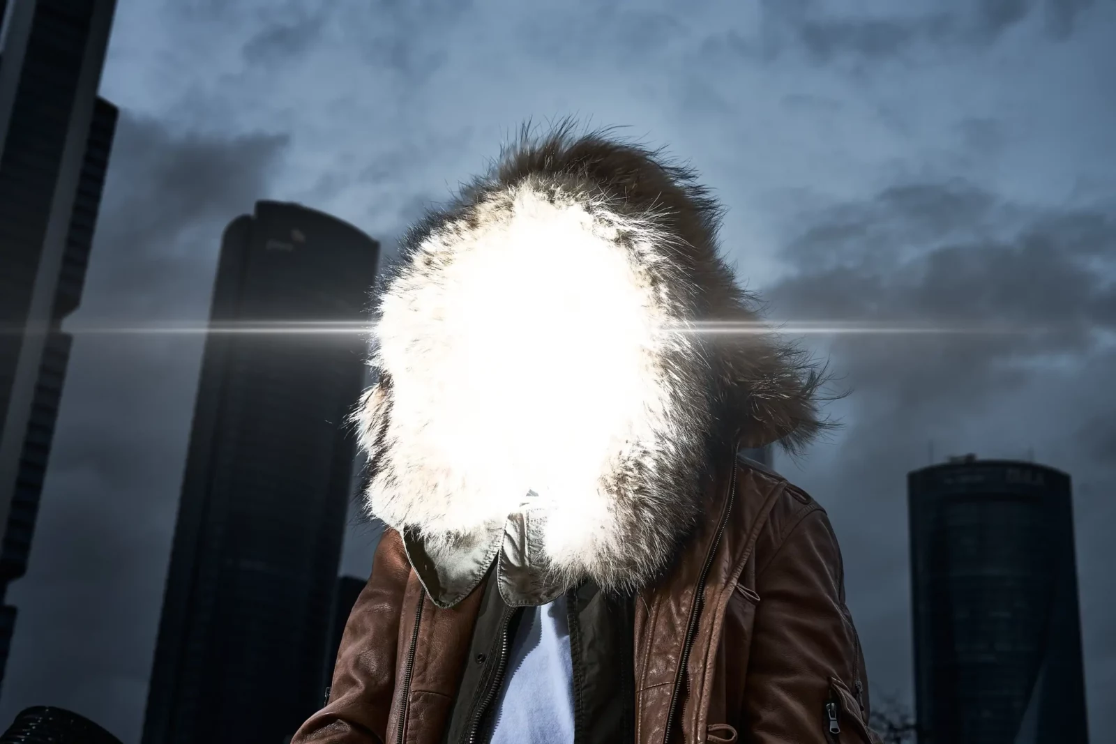 Close-up of a model wearing a large fluffy hood illuminated by a bright flash against city towers.